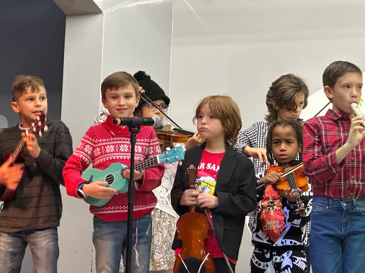 A group of children playing instrumentsDescription automatically generated